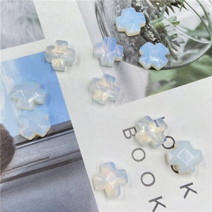 Macro shot of cross-shaped opal beads with faceted surfaces on an aesthetic background