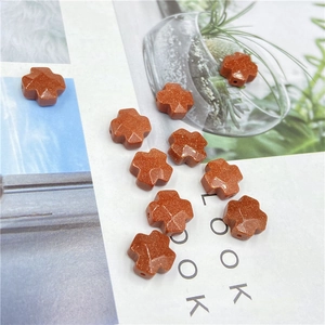 Macro detail of faceted cross-shaped goldstone beads with shimmering gold specks