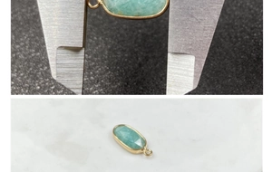 Pendente in pietra verde sfaccettata con bordo dorato e misurazione delle dimensioni reali