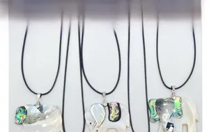 Detailed view of elephant pendants made of natural abalone and white shell on black cord