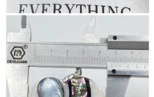 Detailed measurement of shell elephant pendant size using a professional metal caliper