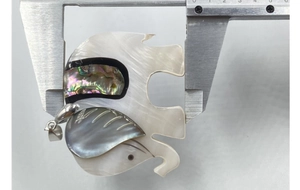 Detail of a shell elephant pendant showing abalone and mother of pearl inlay on calipers