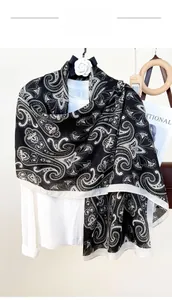 Close-up of black paisley print scarf on a white shirt with camellia decoration