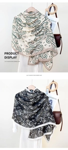 Detail of paisley patterns on soft imitation cashmere scarves in beige and black colors
