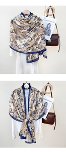 Close-up of beige cotton linen scarf with blue paisley print and navy blue borders