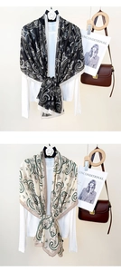 Detail view of cotton linen scarves featuring paisley prints and camellia brooch accents