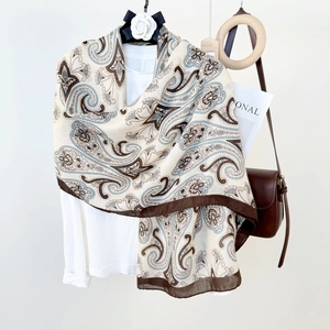 Retro paisley print linen shawl in beige and brown, draped over a white casual t-shirt