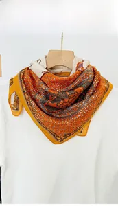 Close-up of vintage horse print silk scarf featuring chain patterns on a wooden hanger