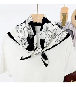 Detail of silk-like neck scarf with camellia floral print styled on a white T-shirt