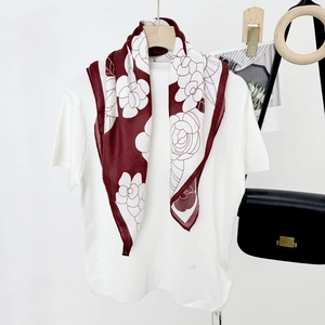 Chic camellia print silk square scarf in burgundy and cream draped on a hanger