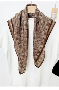 Carré de soie rétro à motif paisley marron suspendu sur un t-shirt blanc avec cintre