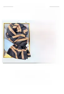 Detailed view of scarf featuring dark brown geometric letter prints and premium texture