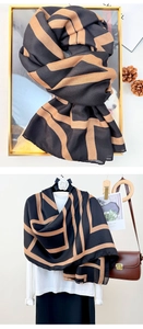 Detail view of cotton linen scarf with geometric stripes on a white shirt and frame