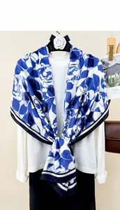 Detail of blue and white floral linen scarf styled over a classic white long sleeve shirt