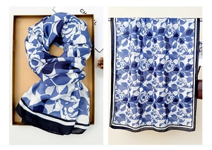 Detail of blue and white floral linen scarf with rose patterns and contrast border