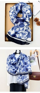 Detail of blue and white rose pattern linen scarf with black border and gift box display