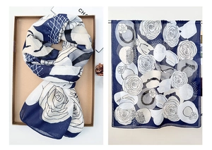 Detailed close-up of camellia flower print and polka dots on elegant blue cotton linen scarf