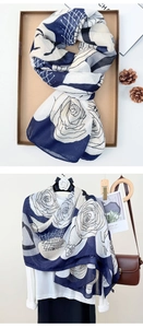 Detail of floral printed scarf in navy and cream folded in a gift box with a rustic setup