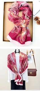 Macro view of feather print cotton linen scarf with deep red and gold tassel detail
