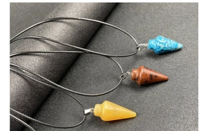 Vue détaillée des pendentifs en pierre naturelle conique sur colliers en cordon noir