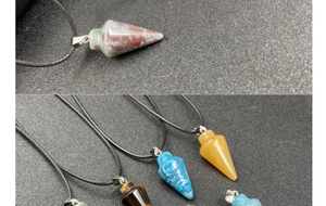 Gros plan détaillé de divers pendentifs en cristal conique en oeil de tigre et quartz