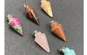 Vue détaillée de divers pendentifs hexagonaux en cristal avec des textures de pierre naturelle