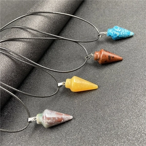 Collier avec pendentif conique en œil de tigre et cordon noir sur fond gris foncé