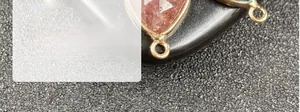 Detail of pink crystal teardrop pendant with gold-plated bezel and hanging loop