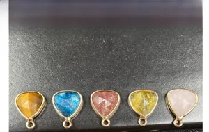 Close-up of faceted teardrop gemstone pendants in gold plating for DIY jewelry making