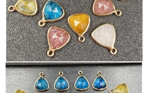 Close-up of faceted teardrop pendants in multiple colors with gold plated metal borders