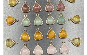 Close-up of faceted water drop charms with gold metal edging for DIY jewelry making