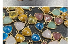 Macro shot of faceted teardrop charms with gold edging for DIY jewelry making