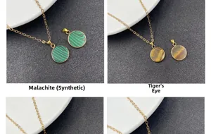 Close-up of gold-plated malachite and tiger eye stone pendants on fine metal chains