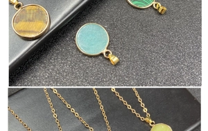 Macro shot of assorted round natural stone pendants with gold plated edges and fine chains
