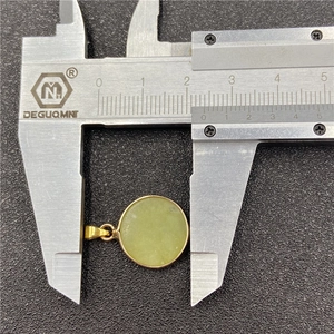 Polished gold bezel set round light green stone pendant measured with a caliper