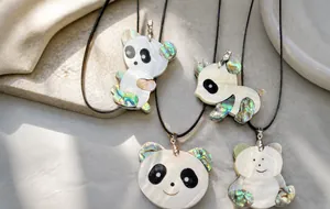 Détail de pendentifs panda en nacre avec un artisanat naturel en coquille irisée