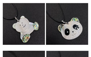 Détail des pendentifs panda et ours en nacre blanche et incrustation d'abalone sur cordon noir