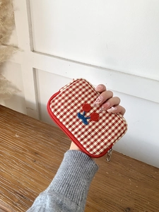 Portable red gingham makeup bag with cherry embroidery and secure zipper closure
