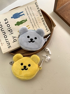 Macro detail of plush bear coin pouches in yellow and blue with metal carabiners