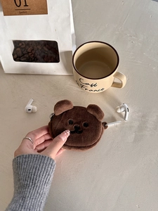 Detailed close-up of brown plush bear coin purse with embroidery and metal clip