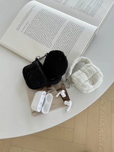 Dettaglio delle mini borse trapuntate in bianco e nero con moschettoni in argento