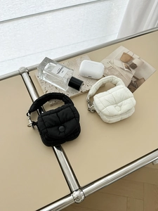 Mini portamonete trapuntati bianchi e neri con ganci in metallo in un set lifestyle
