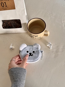 Detail of light blue plush bear coin purse showing embroidery and silver metal carabiner clip