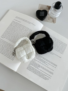 Set di mini pochette a nuvola trapuntate nere e bianche con catene sopra dei libri