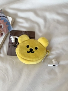 Detailed macro view of yellow plush bear coin purse with zipper and metal hook