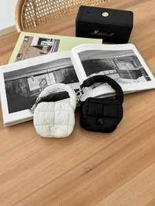 Macro di mini pochette trapuntate in bianco e nero con moschettoni in metallo resistenti