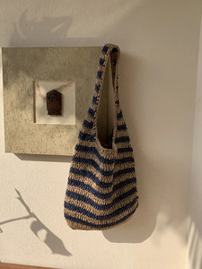 Detail view of navy and khaki striped woven shoulder bag with textured craftsmanship