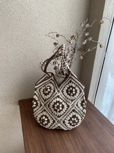 Detailed close-up of the crochet pattern on a brown and white checkered tote bag