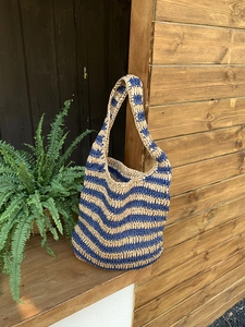 Detailed texture of blue and beige striped woven tote bag with wide shoulder strap