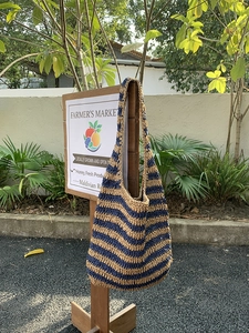 Fashionable woven beach bucket bag with navy and beige stripes for summer vacation